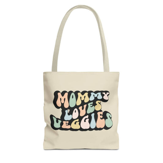 Perfect gift for mom. A beige tote bag, available in three sizes. In a typically 70s retro-style font, it says Mommy Loves Veggies. The handle is beige.
