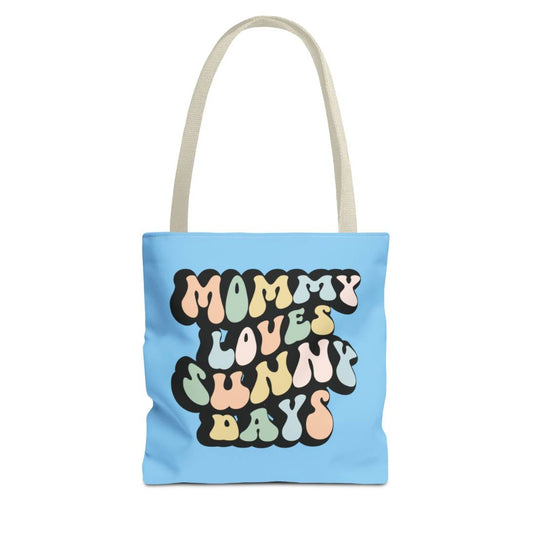 Perfect gift for mom. A light blue tote bag, available in three sizes. In a typically 70s retro-style font, it says Mommy Loves Sunny Days. The handle is beige.