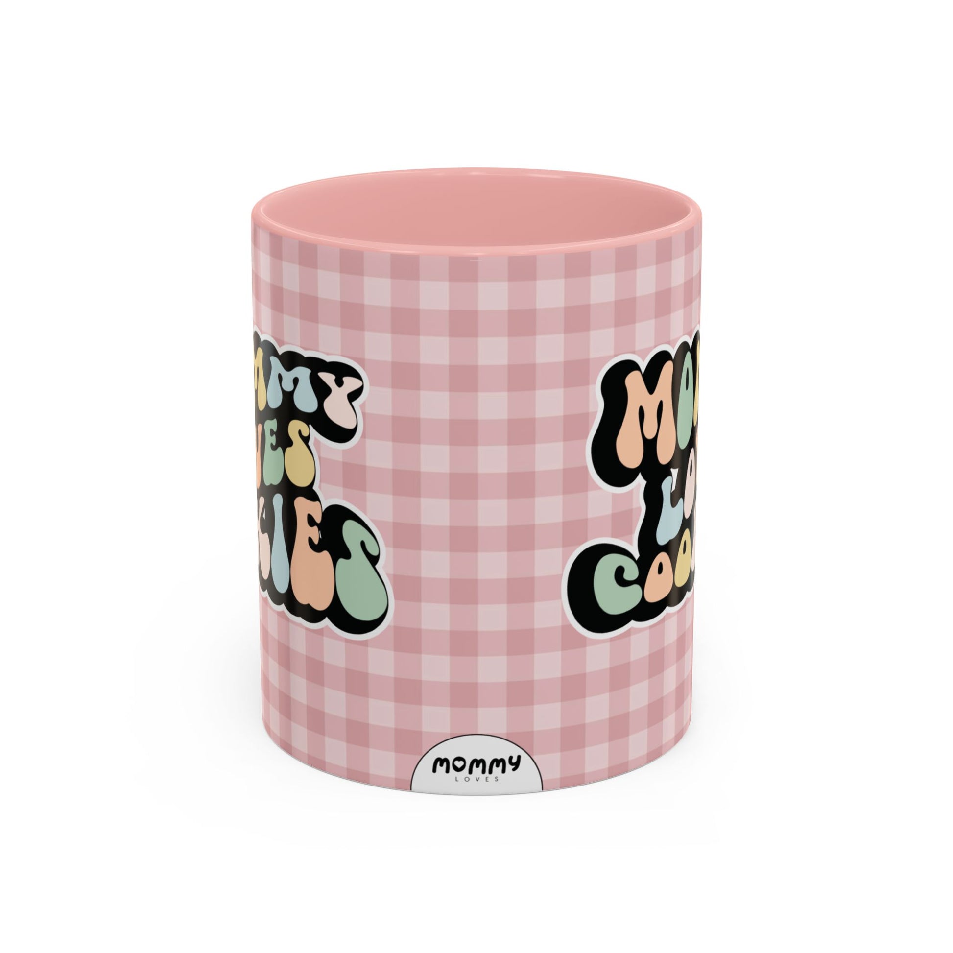 Perfect gift for mom. A decorative, 11oz ceramic mug. It’s wrapped in a soft pink-white checkered background. In a happy and colorful 70s retro-style font it says Mommy Loves Cookies, on both sides.