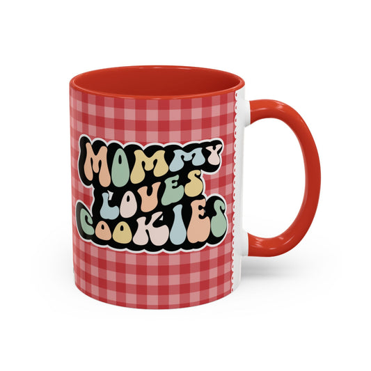 Perfect gift for mom. A decorative, 11oz ceramic mug. It’s wrapped in a red-white checkered background. In a happy and colorful 70s retro-style font it says Mommy Loves Cookies, on both sides.