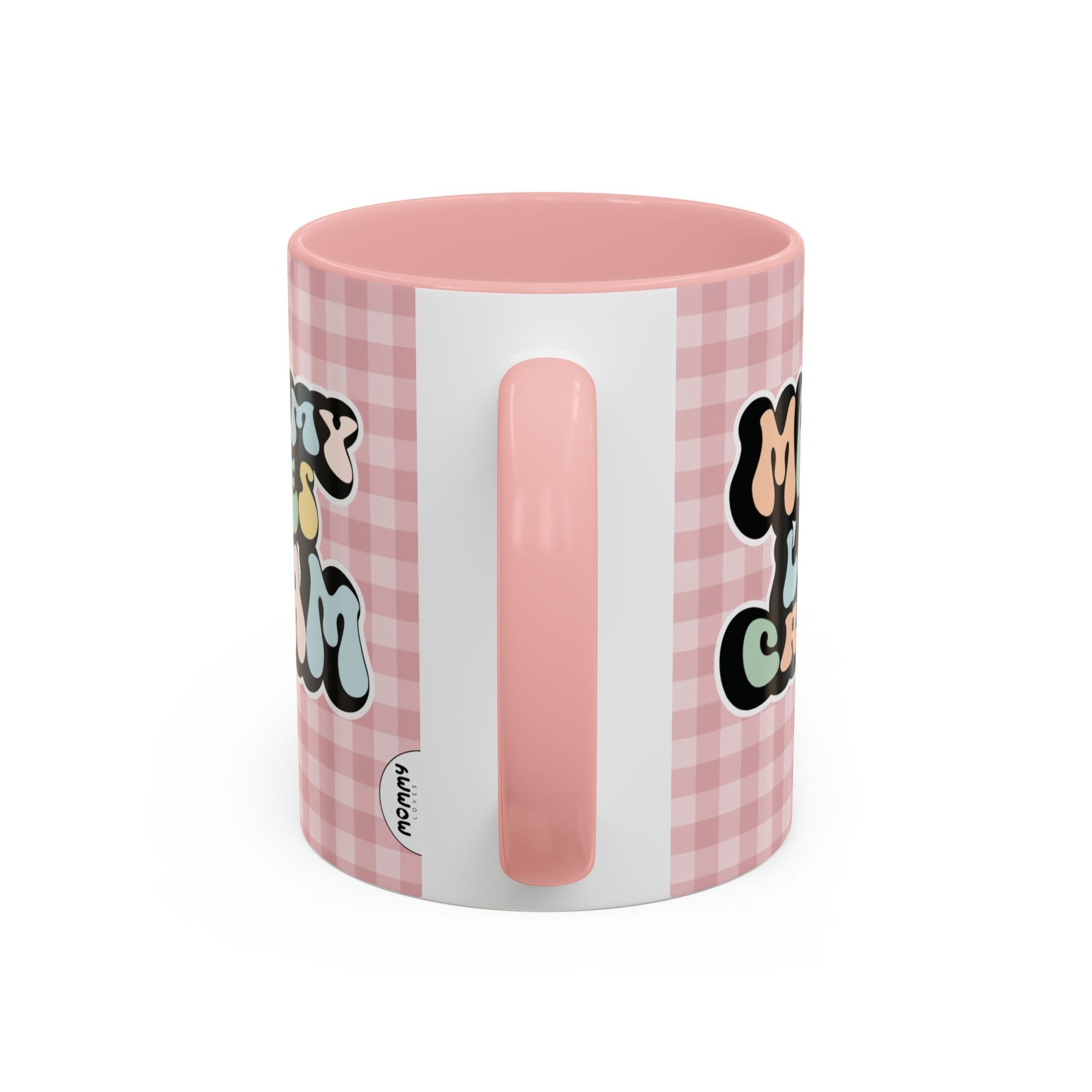 Perfect gift for mom. A decorative, 11oz ceramic mug. It’s wrapped in a soft pink-white checkered background. In a happy and colorful 70s retro-style font it says Mommy Loves Cream, on both sides.