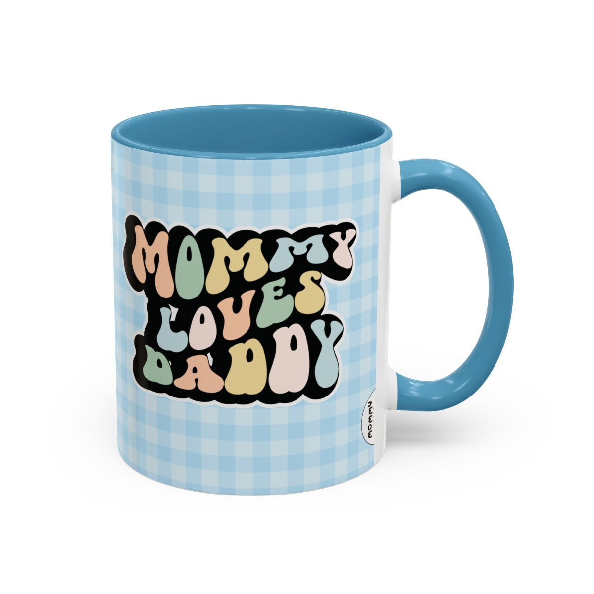 Perfect gift for mom. A decorative, 11oz ceramic mug. It’s wrapped in a light blue-white checkered background. In a happy and colorful 70s retro-style font it says Mommy Loves Daddy, on both sides.