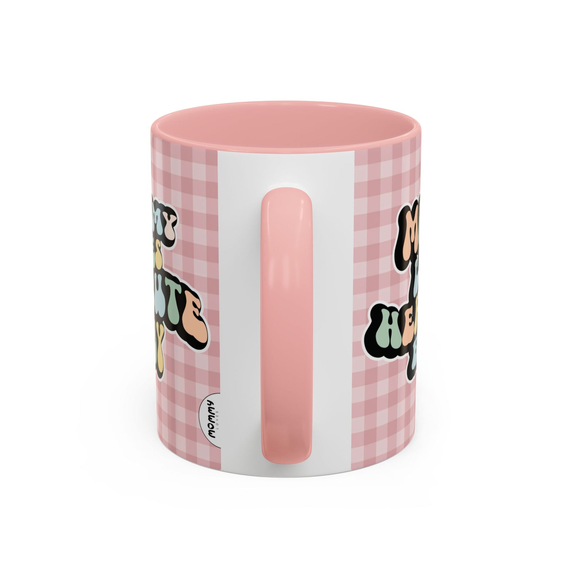 Perfect gift for mom. A decorative, 11oz ceramic mug. It’s wrapped in a soft pink-white checkered background. In a happy and colorful 70s retro-style font it says Mommy Loves Her Cute Baby, on both sides.