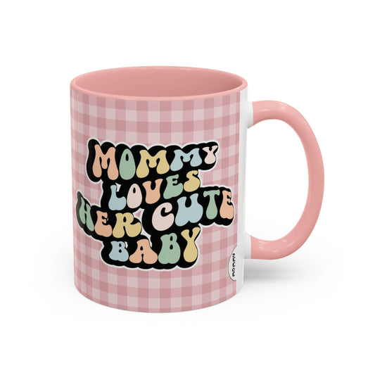 Perfect gift for mom. A decorative, 11oz ceramic mug. It’s wrapped in a soft pink-white checkered background. In a happy and colorful 70s retro-style font it says Mommy Loves Her Cute Baby on both sides.