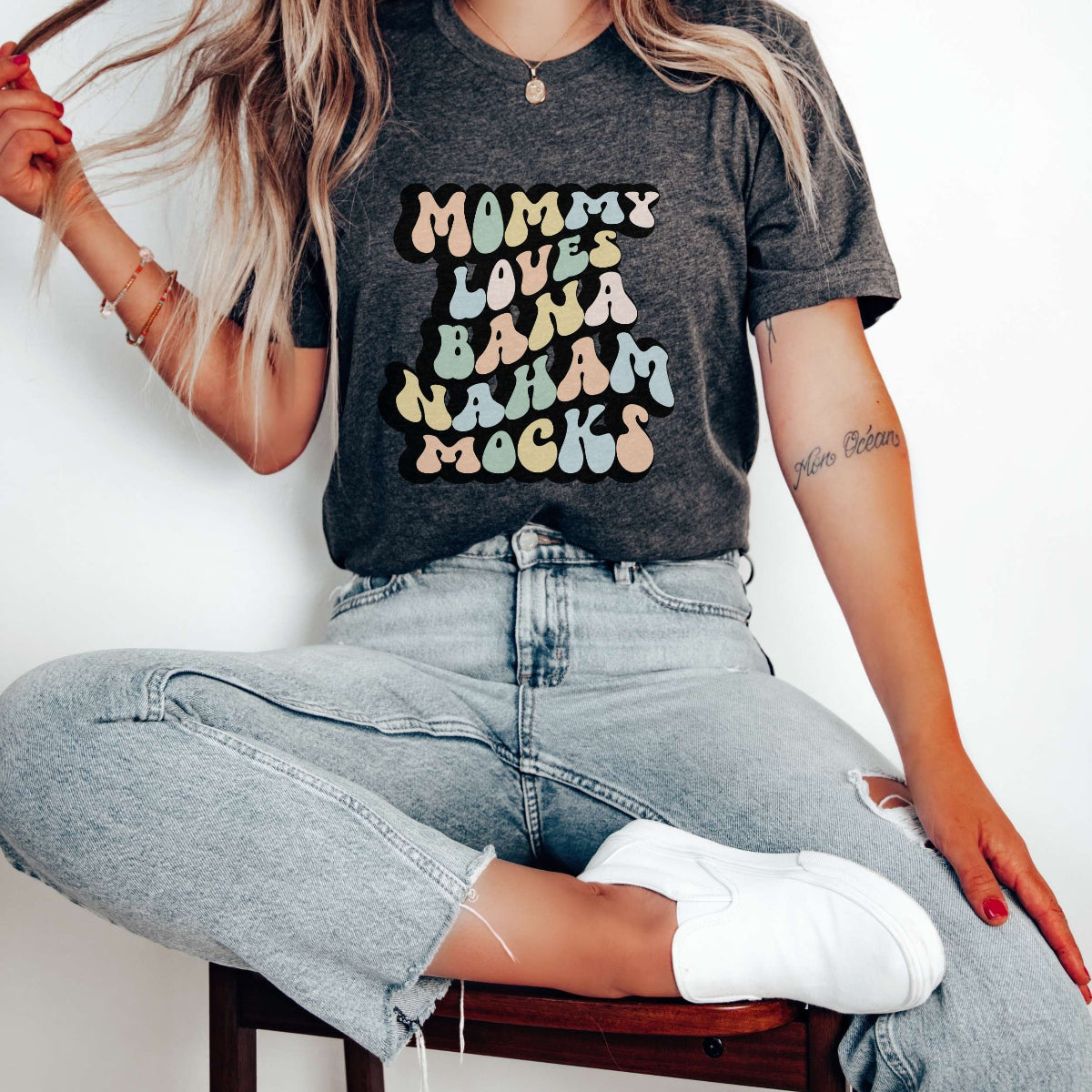 Graphic tee for women. The color of the shirt is gray heather. In a colorful, typically 70s retro-style font it says Mommy Loves Banana Hammocks.