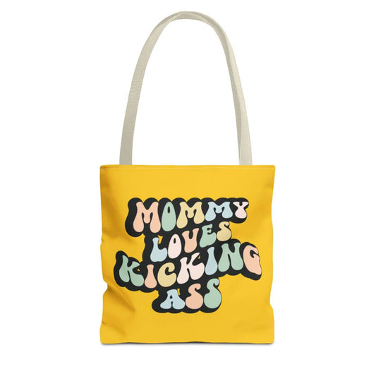 Perfect gift for mom. A yellow mustard tote bag, available in three sizes. In a typically 70s retro-style font, it says Mommy Loves Kicking Ass. 