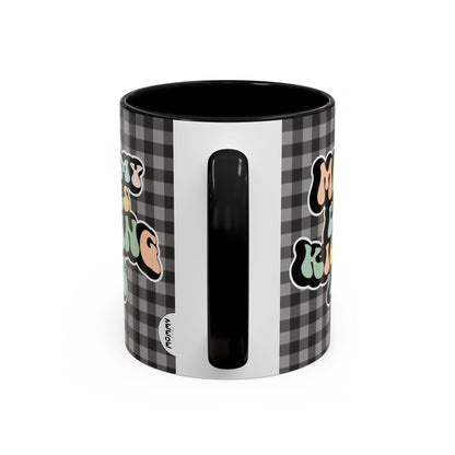 Perfect gift for mom. A decorative, 11oz ceramic mug. It’s wrapped in a black-white checkered background. In a happy and colorful 70s retro-style font it says Mommy Loves Kicking Ass on both sides. 
