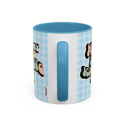 Perfect gift for mom. A decorative, 11oz ceramic mug. It’s wrapped in a light blue-white checkered background. In a happy and colorful 70s retro-style font it says Mommy Loves Kicking Ass on both sides. 