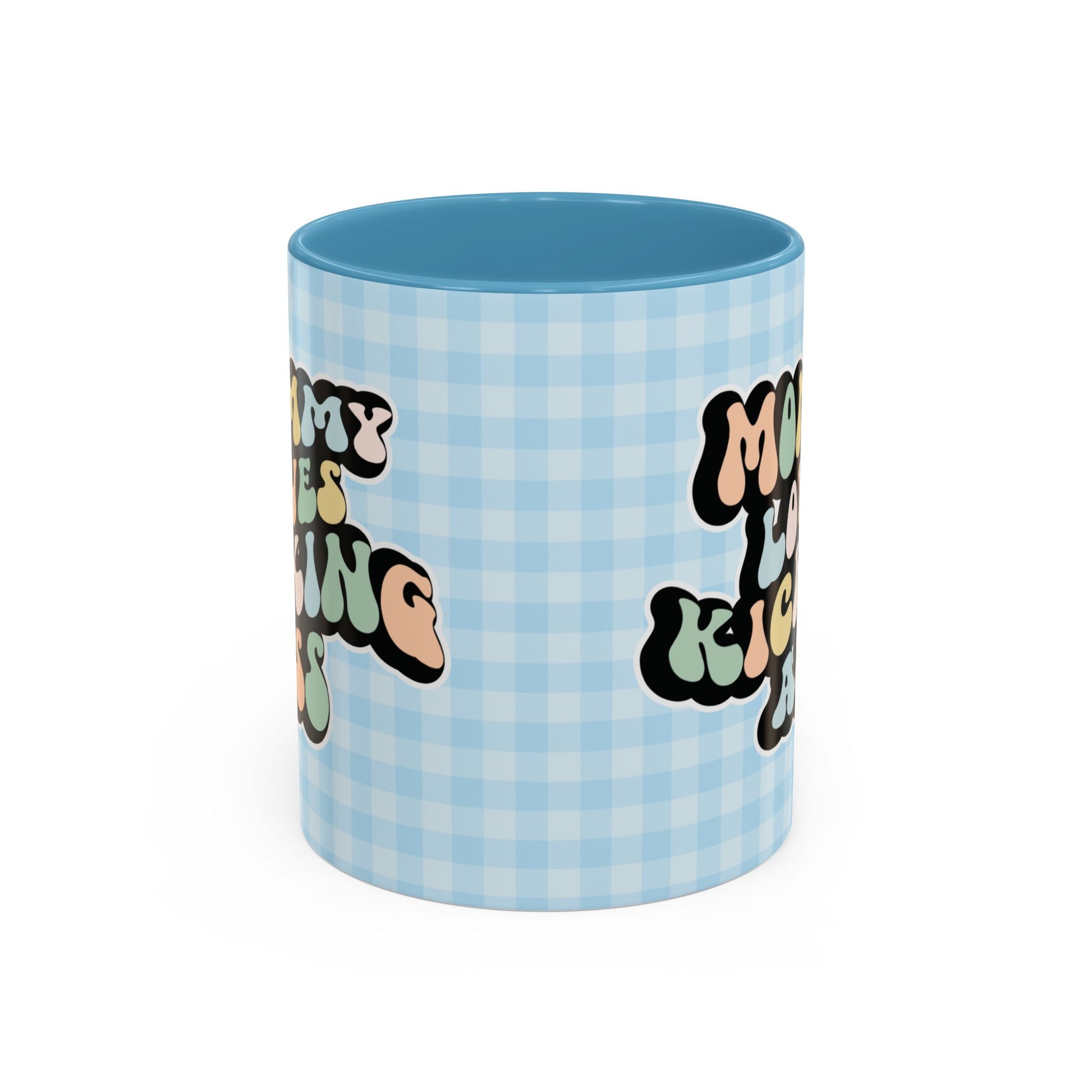 Perfect gift for mom. A decorative, 11oz ceramic mug. It’s wrapped in a light blue-white checkered background. In a happy and colorful 70s retro-style font it says Mommy Loves Kicking Ass on both sides. 