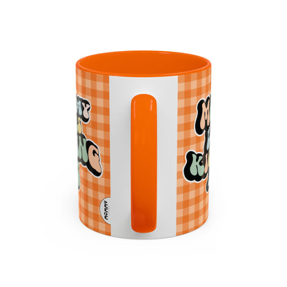 Perfect gift for mom. A decorative, 11oz ceramic mug. It’s wrapped in a orange-white checkered background. In a happy and colorful 70s retro-style font it says Mommy Loves Kicking Ass on both sides. 