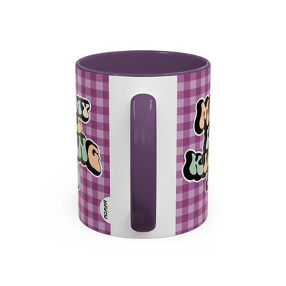 Perfect gift for mom. A decorative, 11oz ceramic mug. It’s wrapped in a purple-white checkered background. In a happy and colorful 70s retro-style font it says Mommy Loves Kicking Ass on both sides. 
