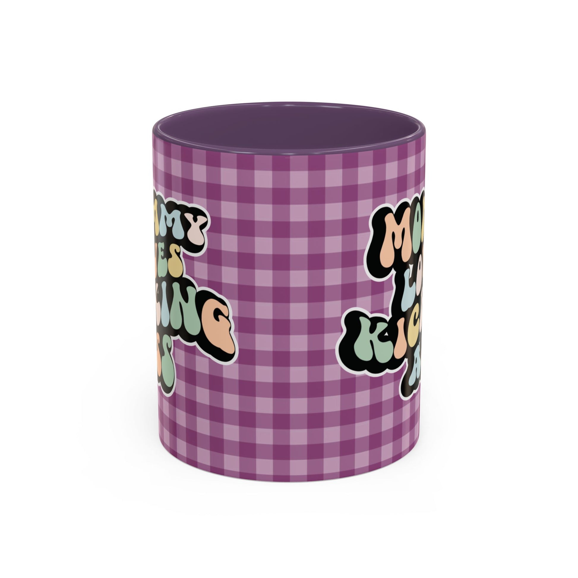 Perfect gift for mom. A decorative, 11oz ceramic mug. It’s wrapped in a purple-white checkered background. In a happy and colorful 70s retro-style font it says Mommy Loves Kicking Ass on both sides. 