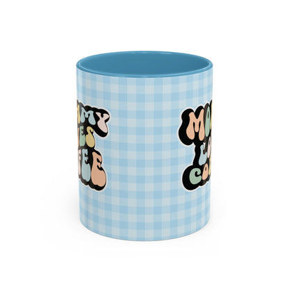 Perfect gift for mom. A decorative, 11oz ceramic mug. It’s wrapped in a light blue-white checkered background. In a happy and colorful 70s retro-style font it says Mommy Loves Coffee, on both sides. 