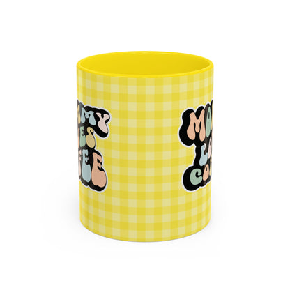 Perfect gift for mom. A decorative, 11oz ceramic mug. It’s wrapped in a yellow-white checkered background. In a happy and colorful 70s retro-style font it says Mommy Loves Coffee, on both sides. 
