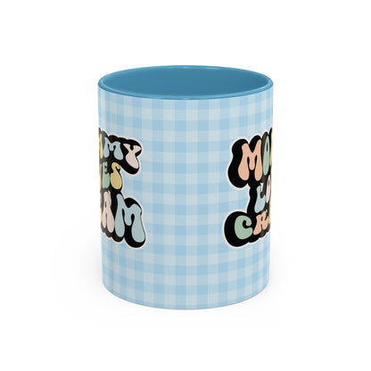 Perfect gift for mom. A decorative, 11oz ceramic mug. It’s wrapped in a light blue-white checkered background. In a happy and colorful 70s retro-style font it says Mommy Loves Cream, on both sides. 