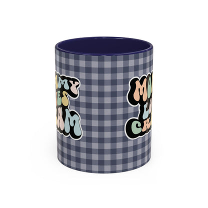 Perfect gift for mom. A decorative, 11oz ceramic mug. It’s wrapped in a navy blue-white checkered background. In a happy and colorful 70s retro-style font it says Mommy Loves Cream, on both sides. 