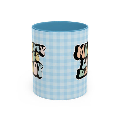 Perfect gift for mom. A decorative, 11oz ceramic mug. It’s wrapped in a light blue-white checkered background. In a happy and colorful 70s retro-style font it says Mommy Loves Daddy, on both sides. 