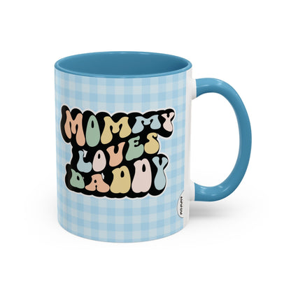 Perfect gift for mom. A decorative, 11oz ceramic mug. It’s wrapped in a light blue-white checkered background. In a happy and colorful 70s retro-style font it says Mommy Loves Daddy, on both sides. 