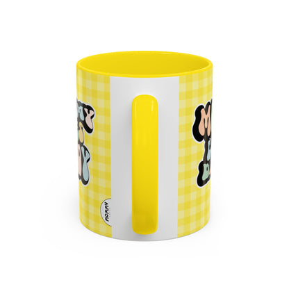 Perfect gift for mom. A decorative, 11oz ceramic mug. It’s wrapped in a yellow-white checkered background. In a happy and colorful 70s retro-style font it says Mommy Loves Daddy, on both sides. 