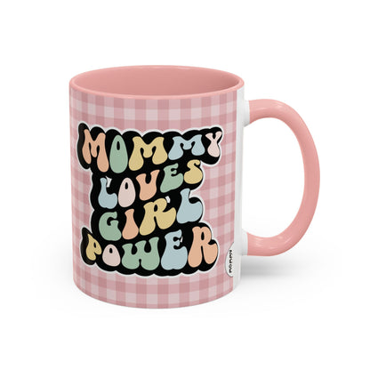 Perfect gift for mom. A decorative, 11oz ceramic mug. It’s wrapped in a soft pink-white checkered background. In a happy and colorful 70s retro-style font it says Mommy Loves Girl Power, on both sides. 