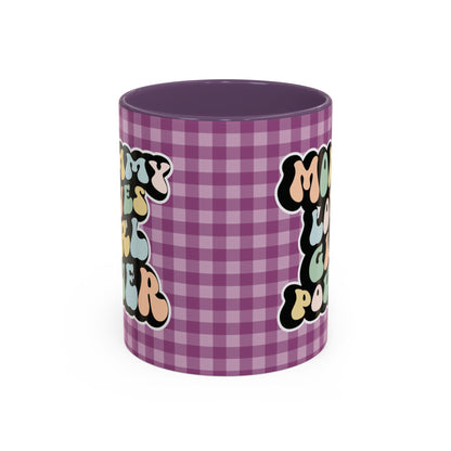 Perfect gift for mom. A decorative, 11oz ceramic mug. It’s wrapped in a purple-white checkered background. In a happy and colorful 70s retro-style font it says Mommy Loves Girl Power, on both sides. 
