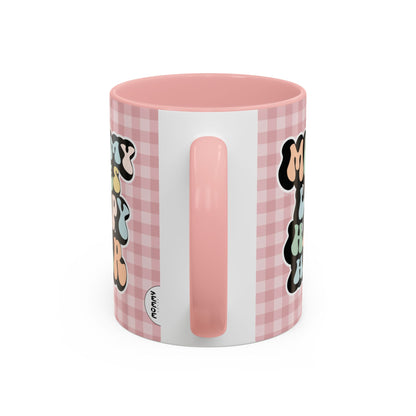Perfect gift for mom. A decorative, 11oz ceramic mug. It’s wrapped in a soft pink-white checkered background. In a happy and colorful 70s retro-style font it says Mommy Loves Happy Hour, on both sides. 