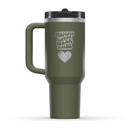 The back side of the newest Stanley 40oz Tumbler. The perfect gift for mom. The Color of the cup is Dried Pine, a dark shade of army green. It’s engraved with a typically 70s retro-style font, saying Mommy Loves Weekends. Under that text there is a nice big heart in the same retro style.