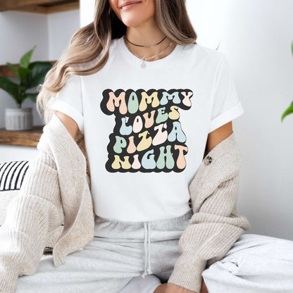 Graphic tee for women. The color of the shirt is white. In a colorful, typically 70s retro-style font it says Mommy Loves Pizza Night.